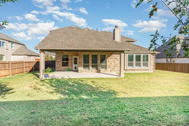 a view of a house with a big yard and a large tree