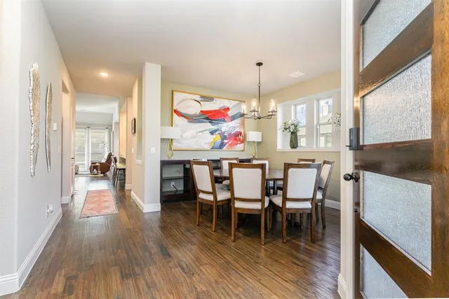 a dining room with furniture a chandelier and wooden floor