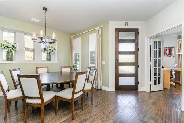 a dining room with furniture a chandelier and wooden floor