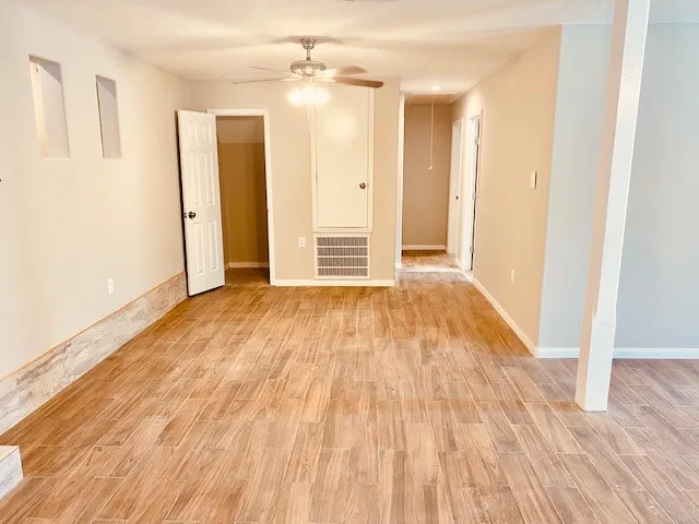 a view of empty room with wooden floor