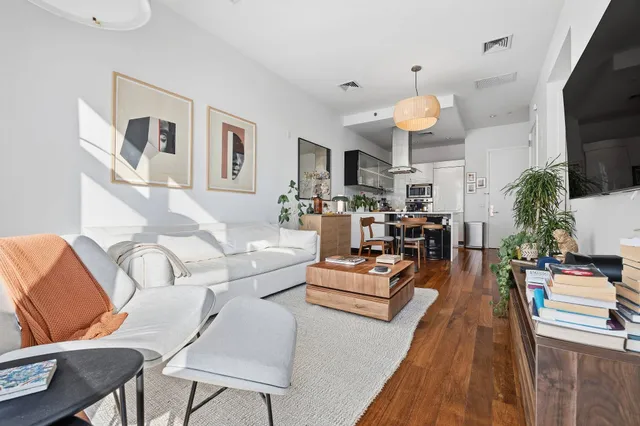 a living room with furniture a flat screen tv and a large window