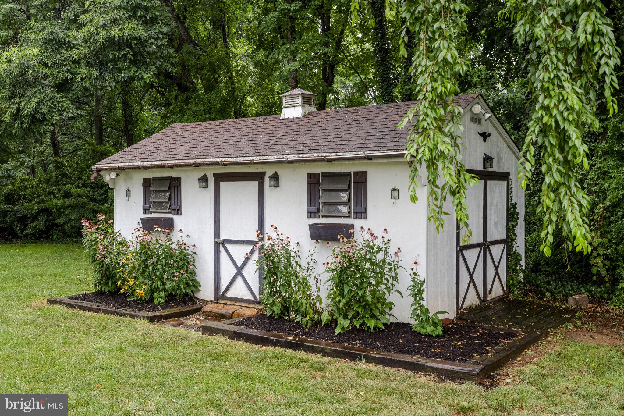 65 Compass Road Parkesburg, PA 19365 - Photo 21 of 61 Charming garden shed nestled in greenery.