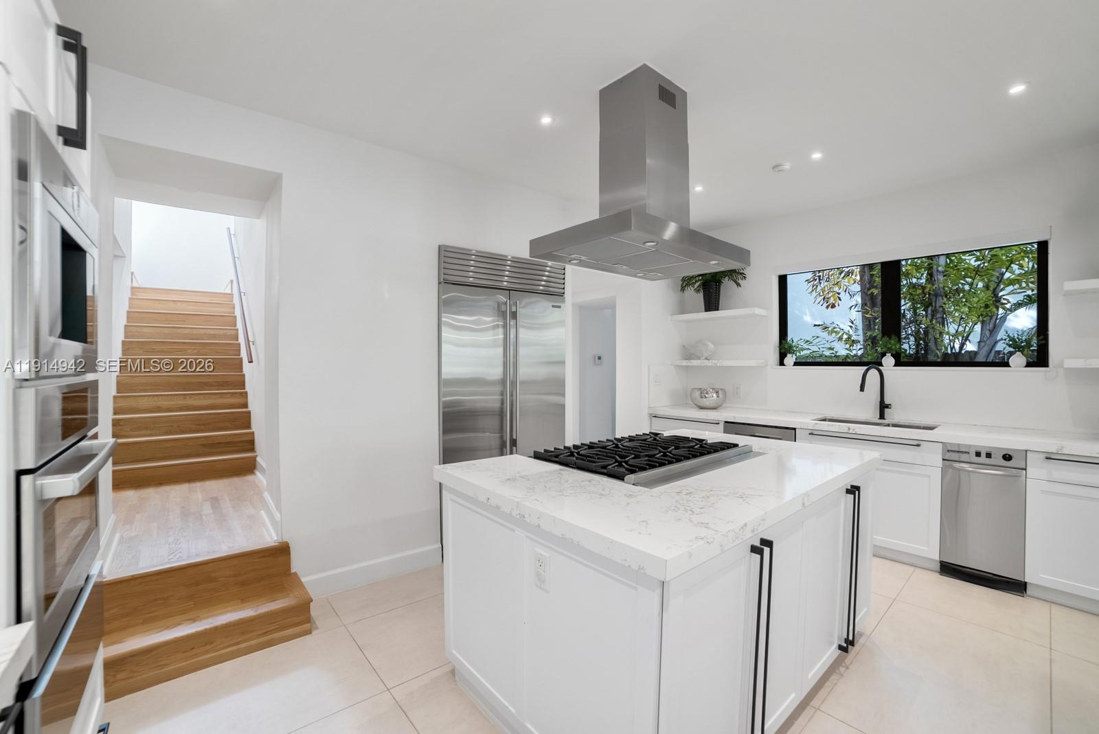 5735 North Bay Road Miami Beach, FL 33140 - Photo 19 of 59 a kitchen that has a sink a stove and a microwave