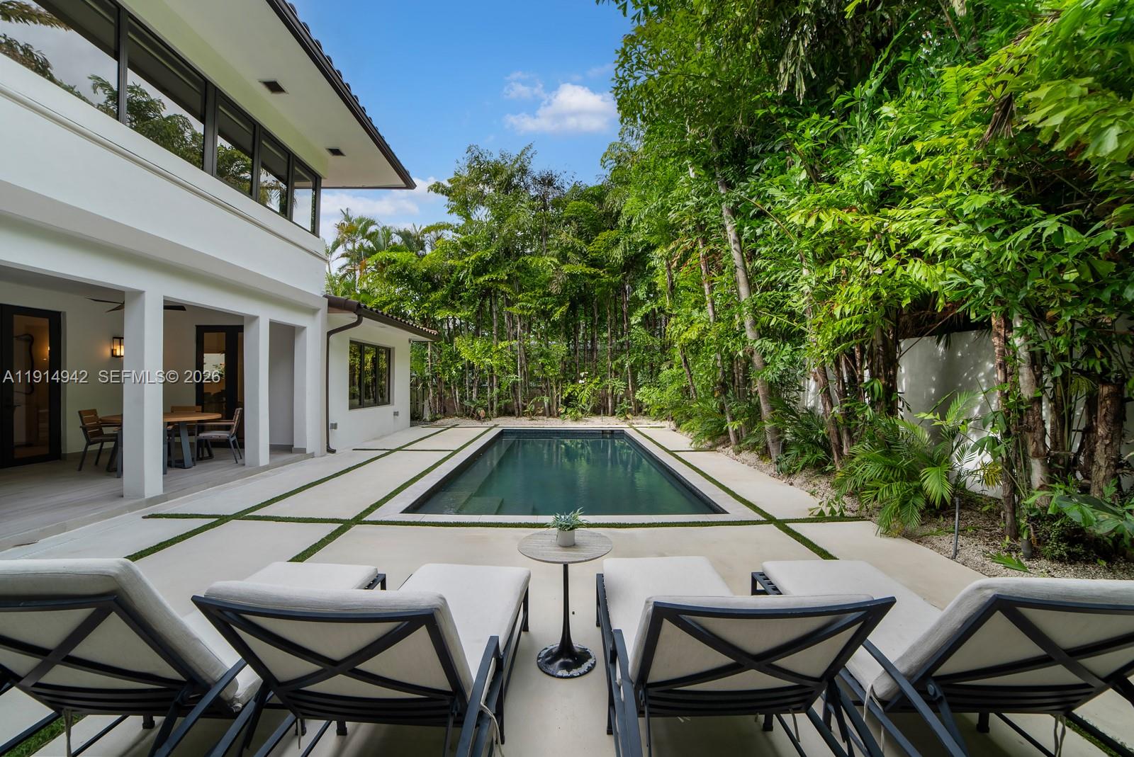 5735 North Bay Road Miami Beach, FL 33140 - Photo 23 of 59 a backyard of a house with table and chairs