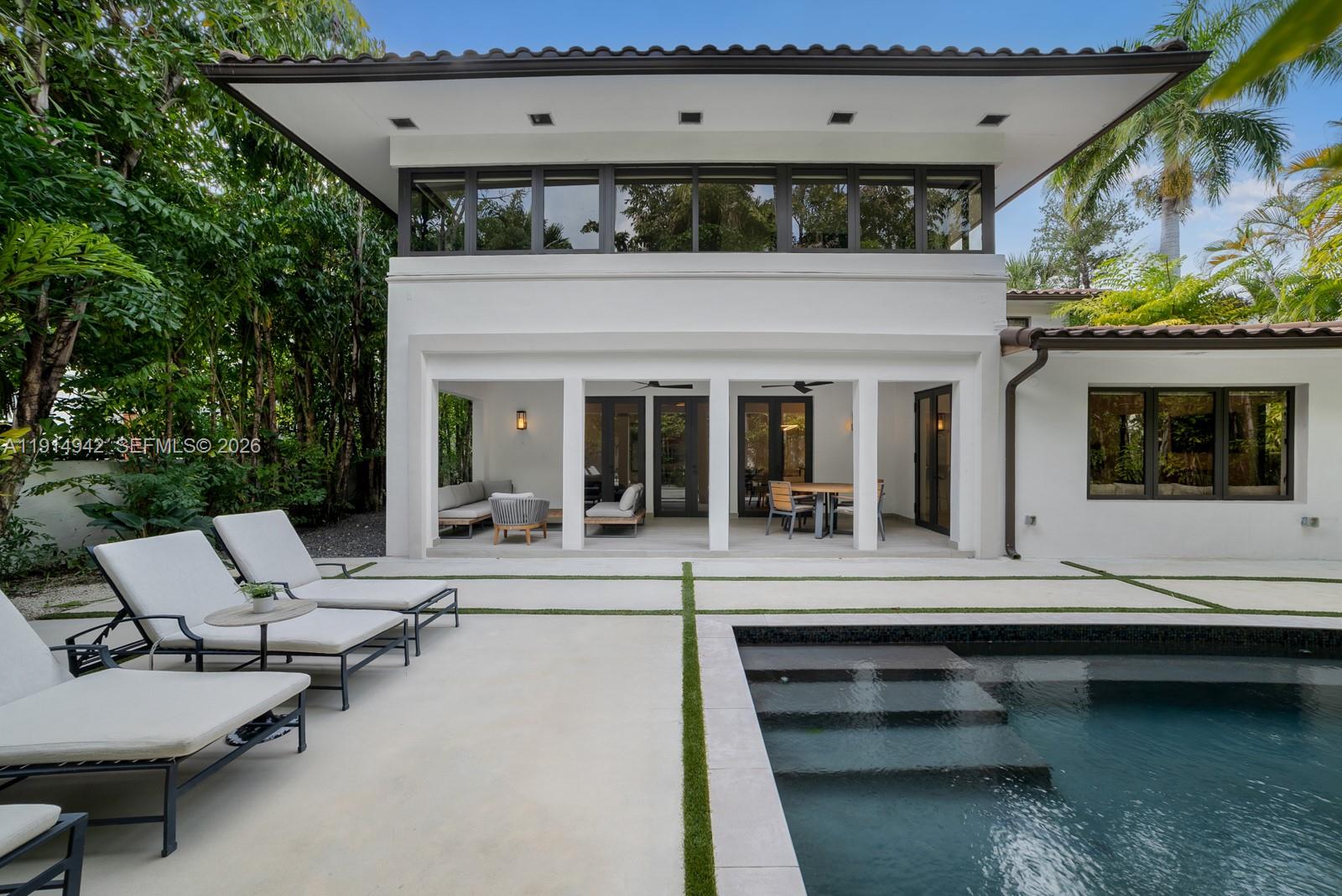 5735 North Bay Road Miami Beach, FL 33140 - Photo 24 of 59 a view of house with swimming pool and chairs