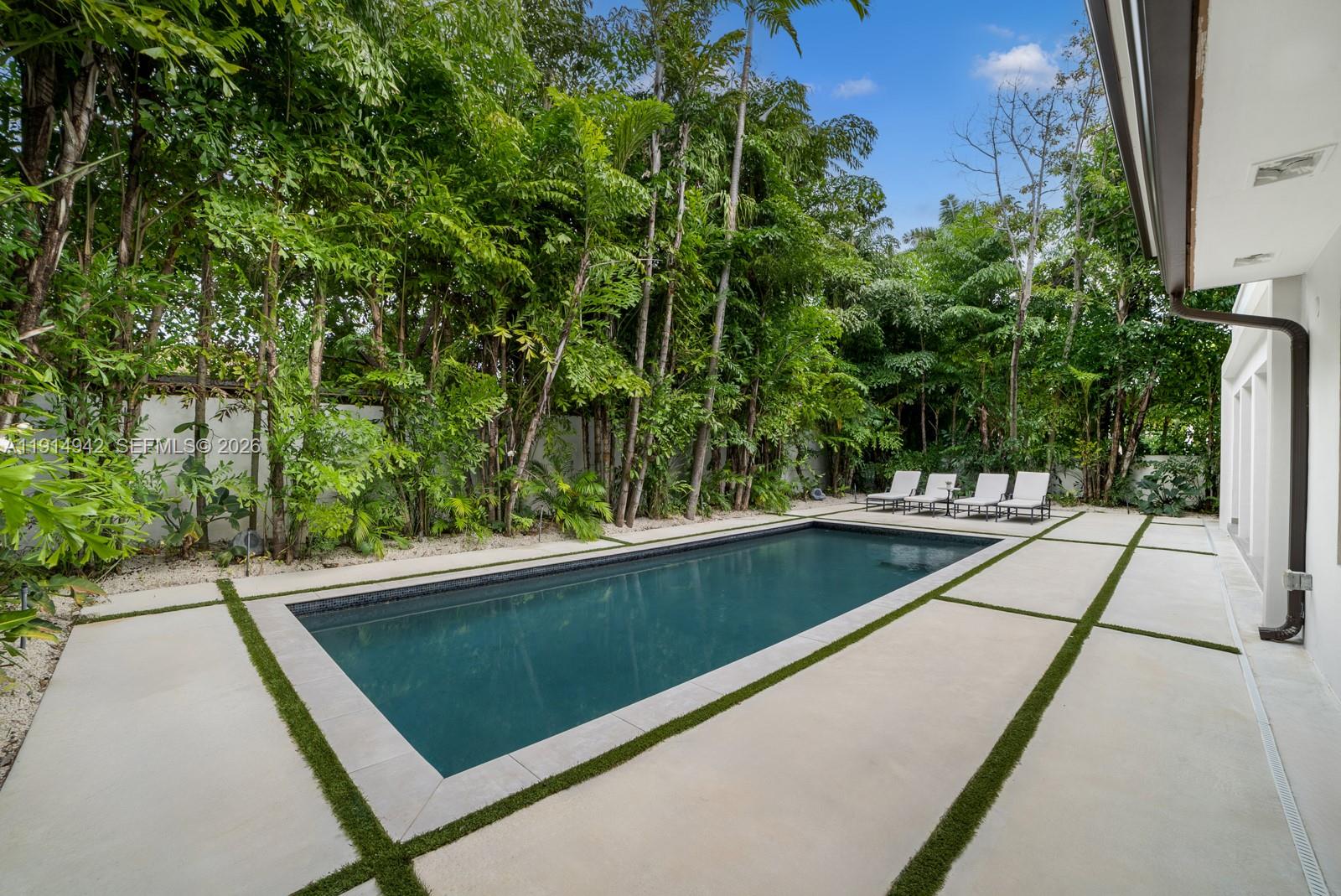 5735 North Bay Road Miami Beach, FL 33140 - Photo 26 of 59 a view of a pool with a bench in front of it