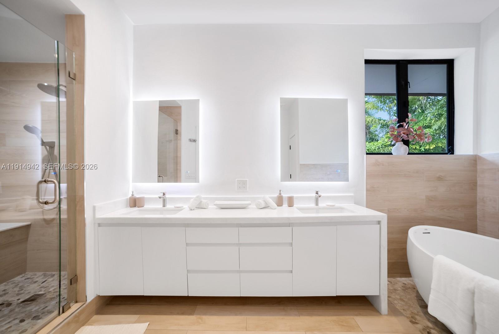 5735 North Bay Road Miami Beach, FL 33140 - Photo 33 of 59 a bathroom with a double vanity sink mirror and bathtub