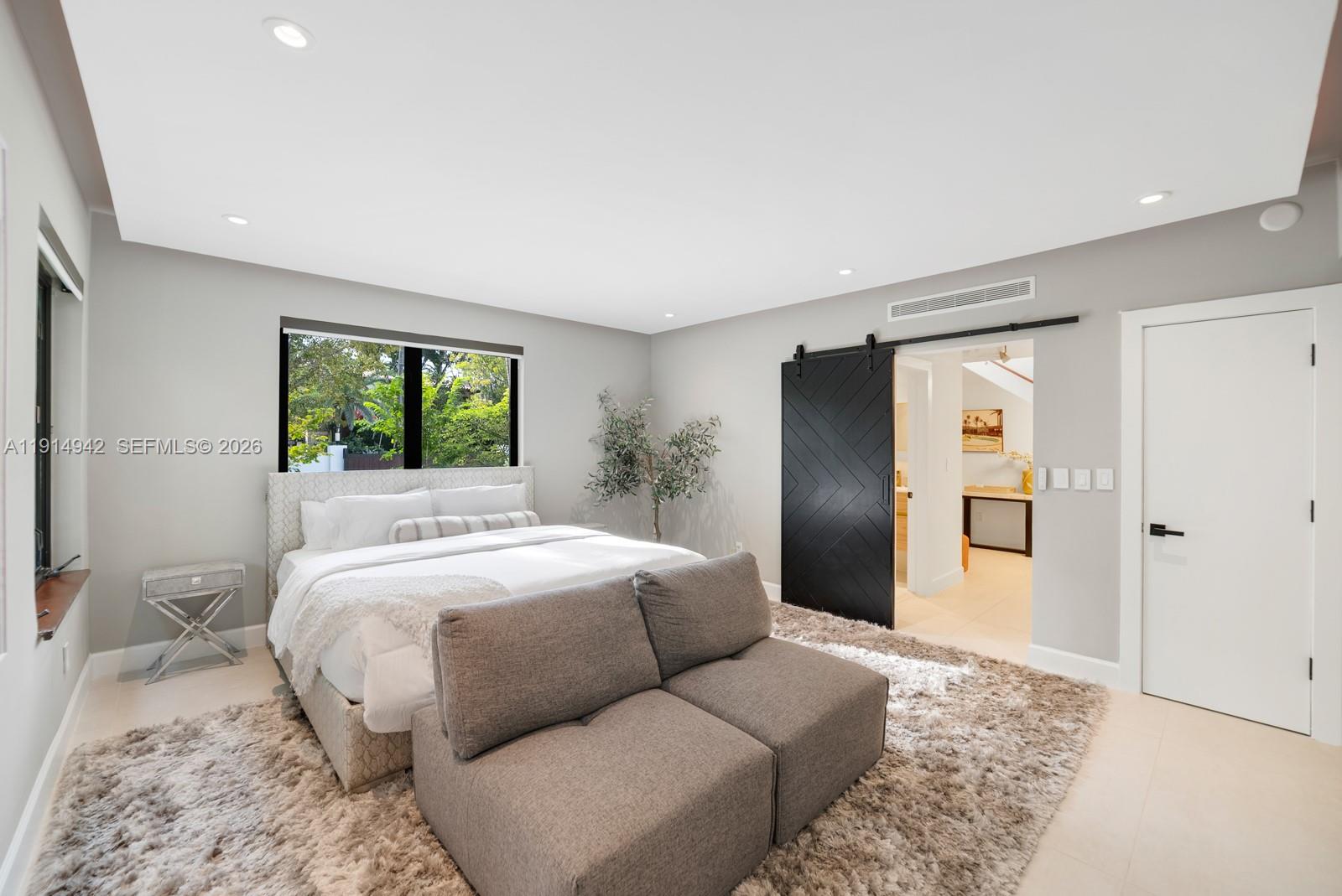 5735 North Bay Road Miami Beach, FL 33140 - Photo 37 of 59 a bedroom with a large bed and a couch