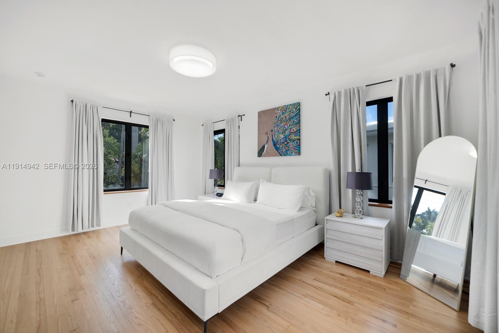5735 North Bay Road Miami Beach, FL 33140 - Photo 41 of 59 a bedroom with a bed wooden floor and a mirror