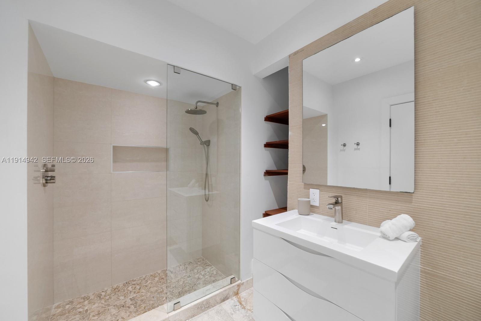 5735 North Bay Road Miami Beach, FL 33140 - Photo 42 of 59 a bathroom with a shower sink and mirror