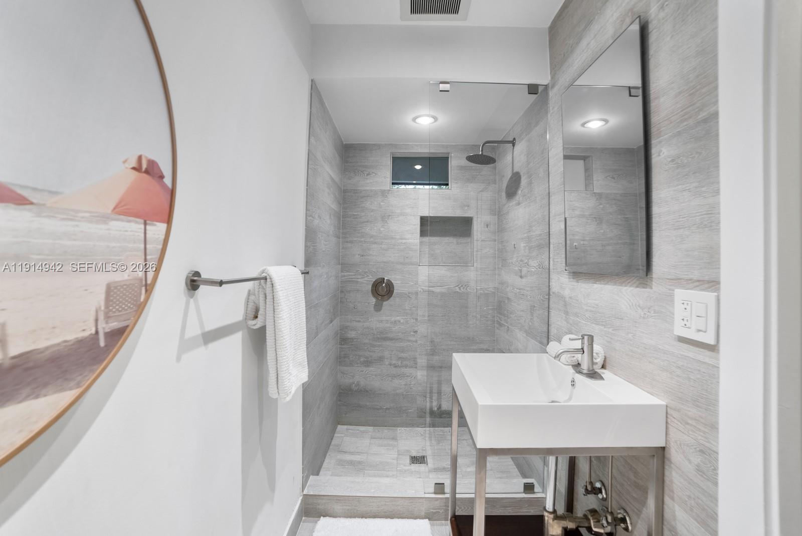 5735 North Bay Road Miami Beach, FL 33140 - Photo 45 of 59 a bathroom with a sink and mirror