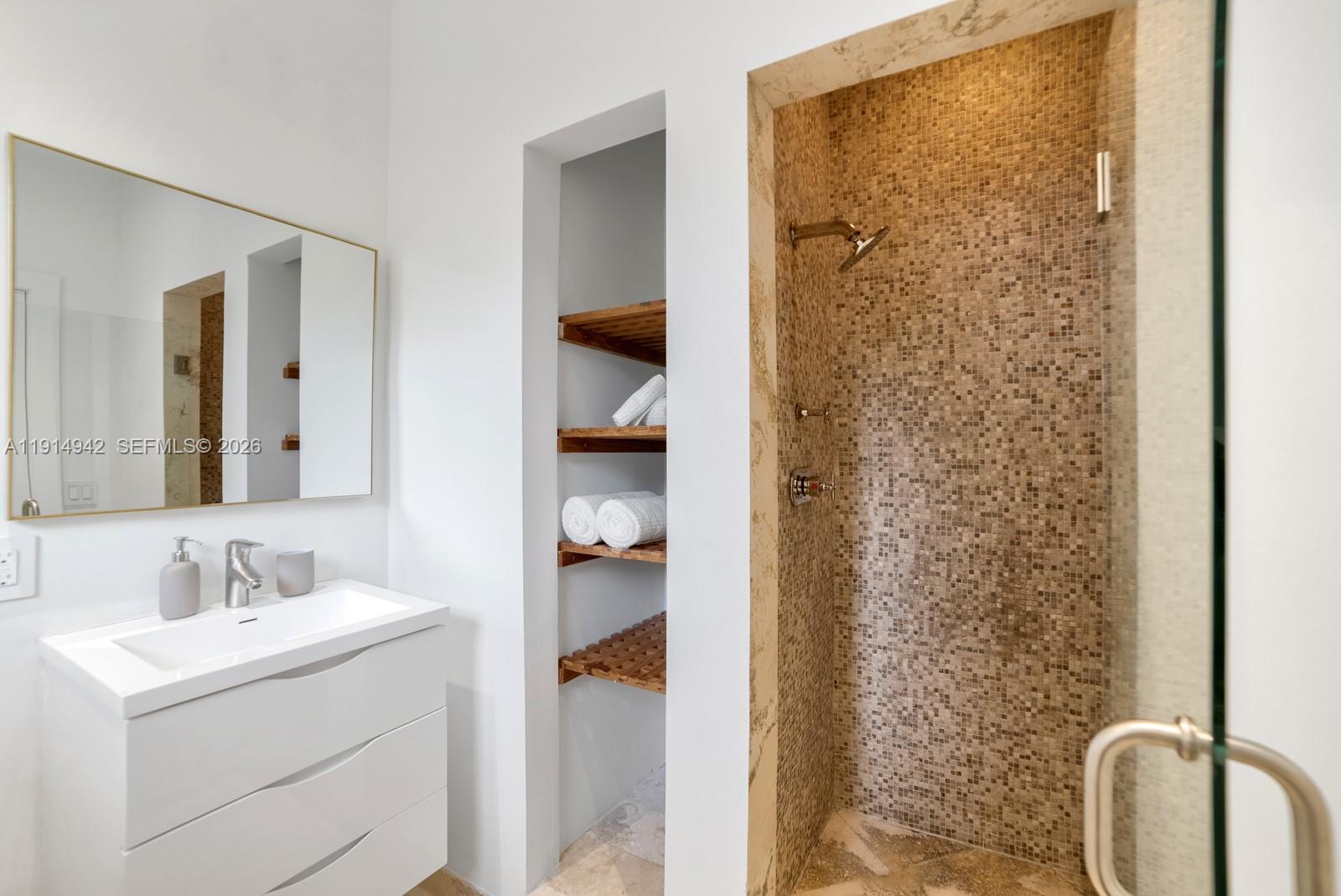 5735 North Bay Road Miami Beach, FL 33140 - Photo 48 of 59 a bathroom with a sink and a mirror