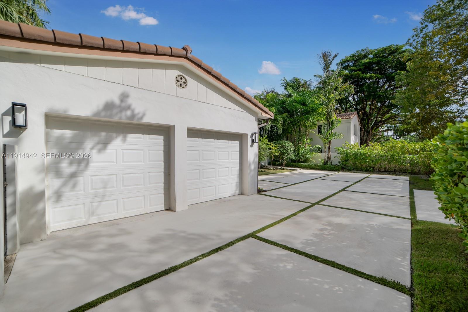 5735 North Bay Road Miami Beach, FL 33140 - Photo 52 of 59 a front view of a house with a yard and garage