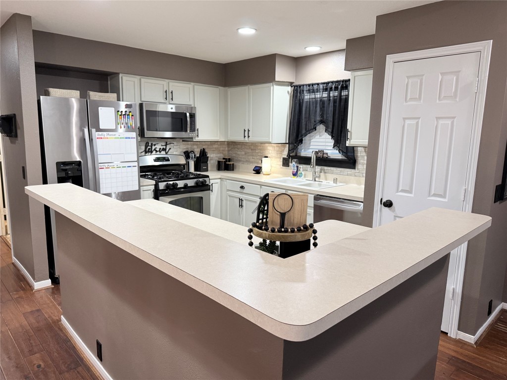 11903 Ezekiel Road Tomball, TX 77375 - Photo 5 of 39 a kitchen with a sink a stove a refrigerator and white cabinets