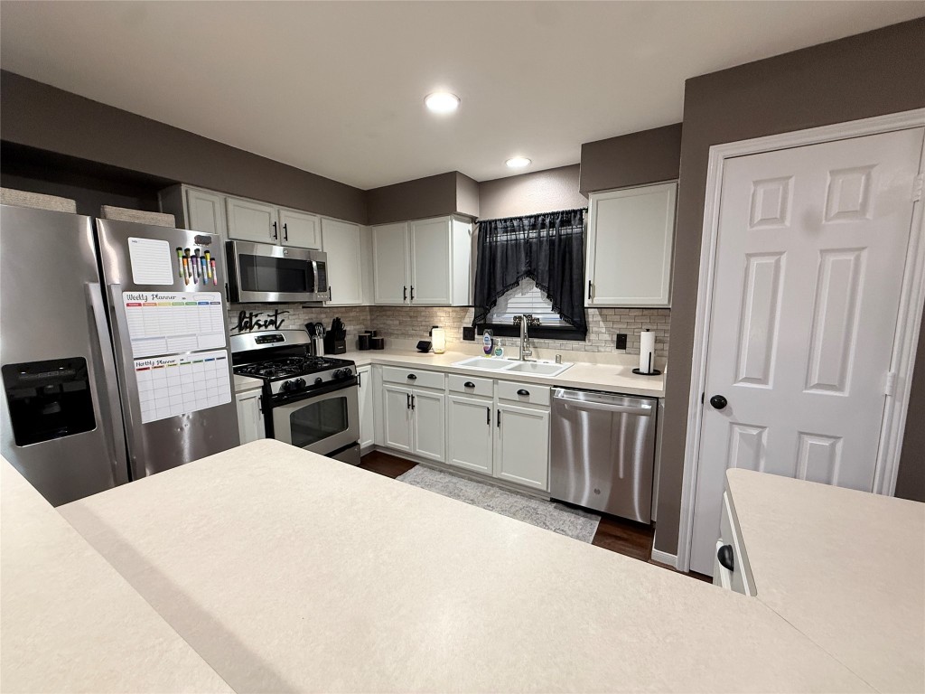 11903 Ezekiel Road Tomball, TX 77375 - Photo 6 of 39 a kitchen with a sink a stove and refrigerator