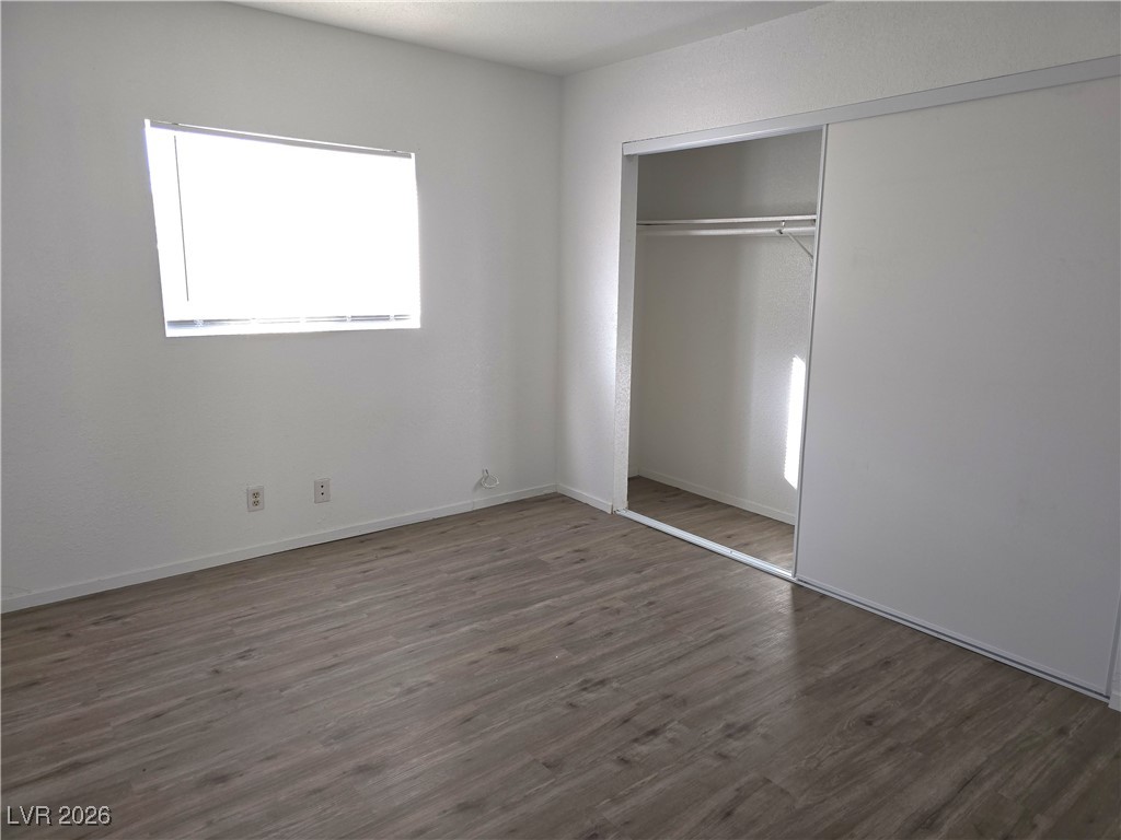 1812 Fulstone Way, Unit 2 Las Vegas, NV 89115 - Photo 6 of 9 Unfurnished bedroom with dark wood finished floors and a closet