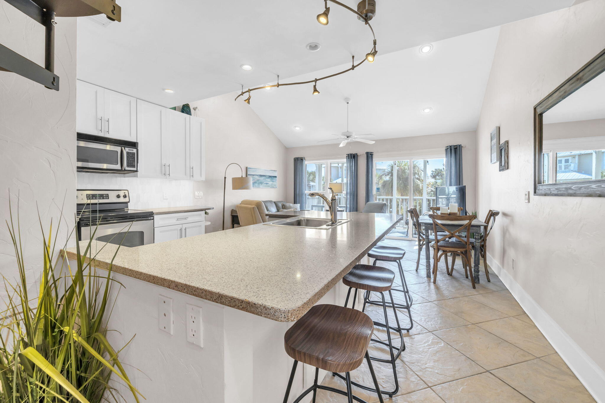 4984 West County Highway 30A, Unit 4B Santa Rosa Beach, FL 32459 - Photo 12 of 37 a kitchen with stainless steel appliances kitchen island granite countertop a refrigerator a stove a dining table and chairs with wooden floor