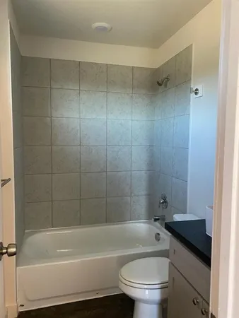 a bathroom with a granite countertop toilet a sink and bathtub