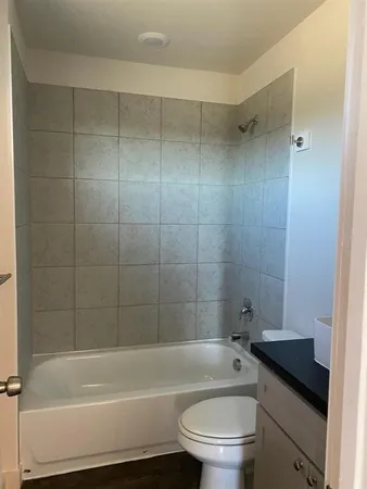 a bathroom with a granite countertop toilet a sink and bathtub