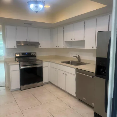 a kitchen with cabinets stainless steel appliances and a sink