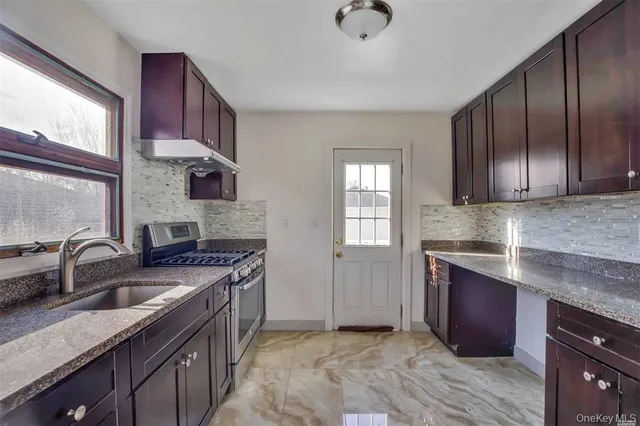 a kitchen with stainless steel appliances granite countertop a sink stove and cabinets