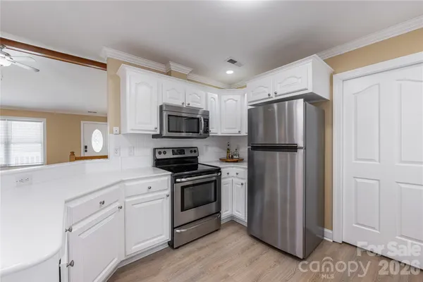 a kitchen with white cabinets and stainless steel appliances