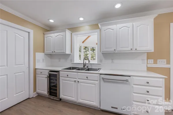 a kitchen with white cabinets and sink