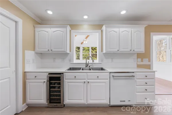 a kitchen with white cabinets and sink