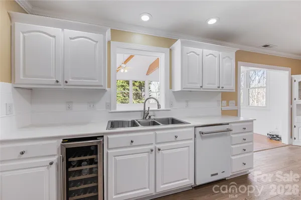 a kitchen with cabinets appliances a sink and a window