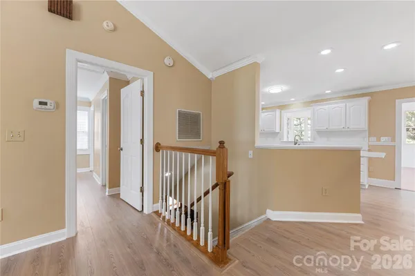 a view of a hallway with wooden floor and kitchen