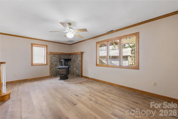 a view of an empty room with a window and a fireplace