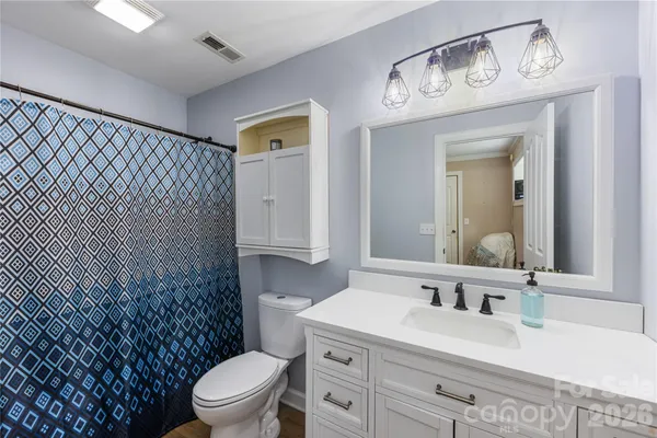 a bathroom with a granite countertop toilet sink and mirror