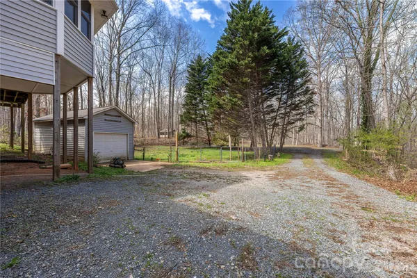 a view of a house with a big yard and large tree