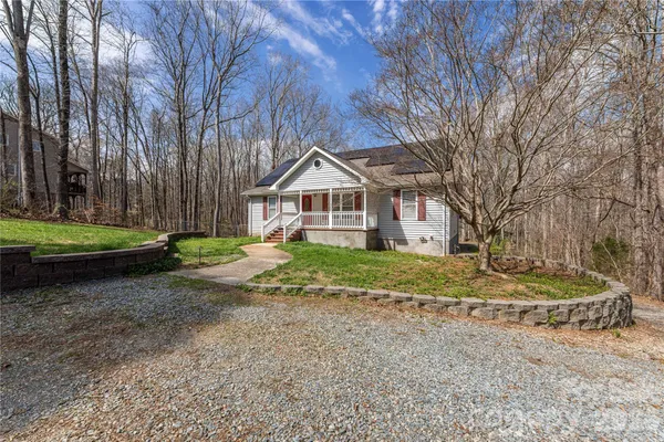 a front view of a house with a yard and trees