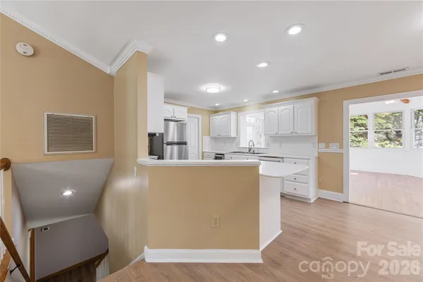 a kitchen with stainless steel appliances granite countertop a refrigerator sink and white cabinets