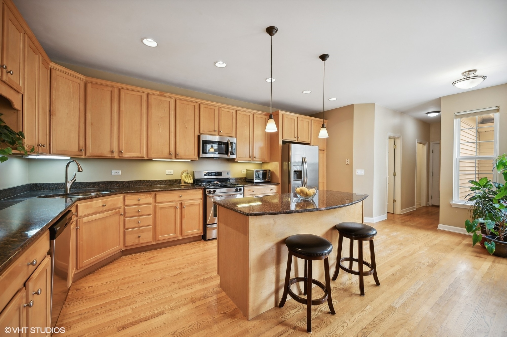 2703 Langley Circle Glenview, IL 60026 - Photo 5 of 23 a kitchen with stainless steel appliances granite countertop a stove top oven a sink dishwasher a dining table and chairs with wooden floor