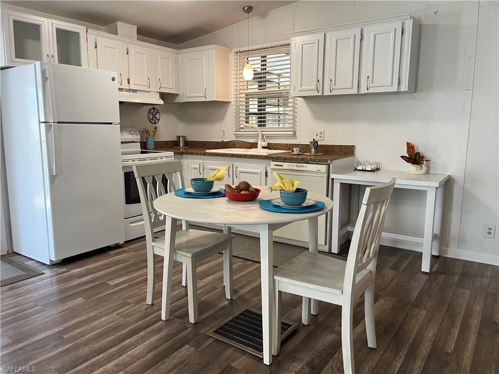 53 Oceans Boulevard, Unit 53 Naples, FL 34104 - Photo 8 of 42 a kitchen with stainless steel appliances a dining table chairs a refrigerator and cabinets