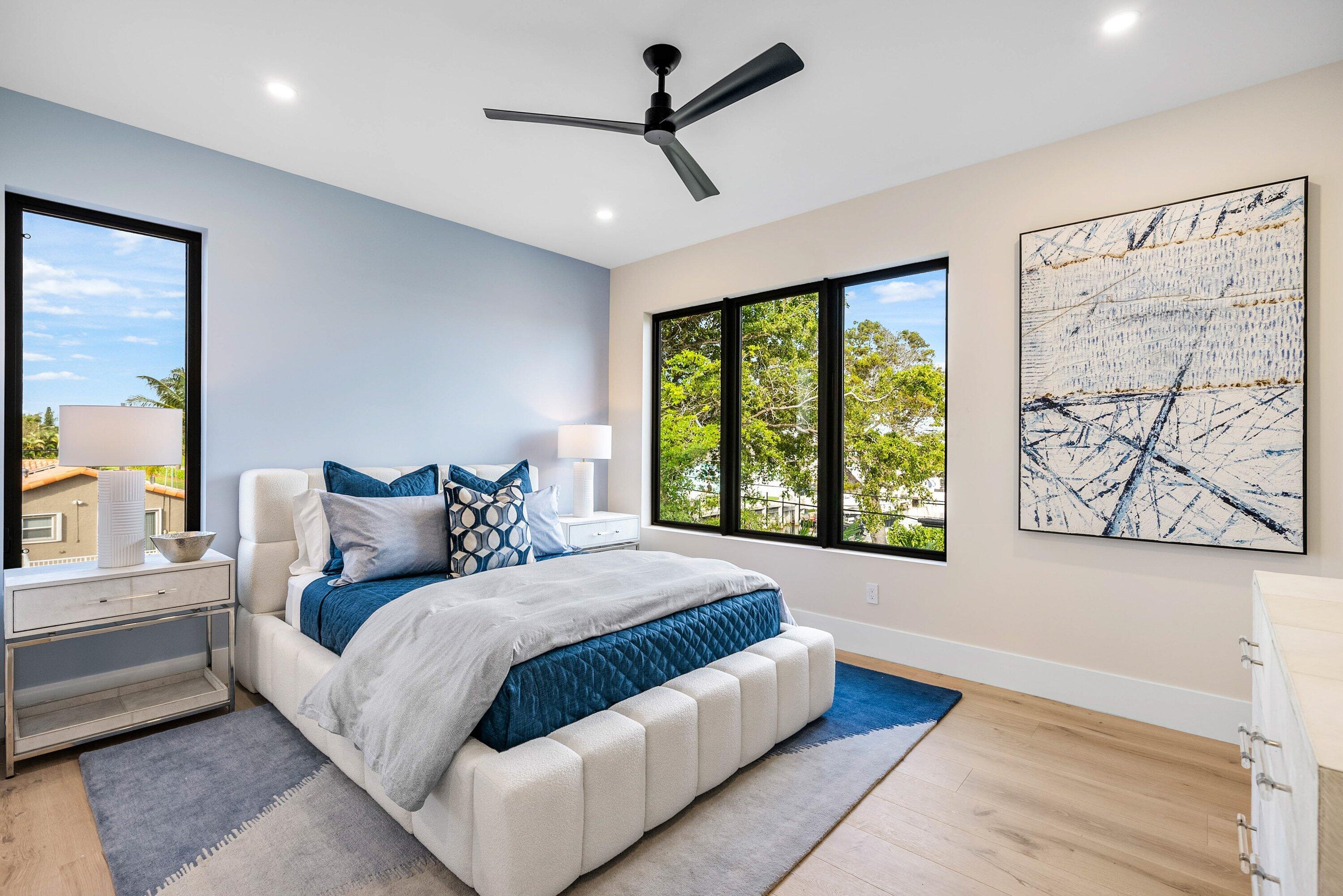 728 Enfield Street Boca Raton, FL 33487 - Photo 18 of 50 a bedroom with a large bed and a chandelier