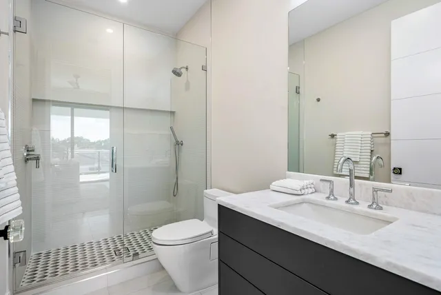 a bathroom with a sink a toilet and shower