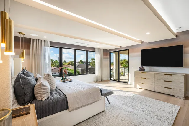 a large bedroom with a bed and large flat screen tv