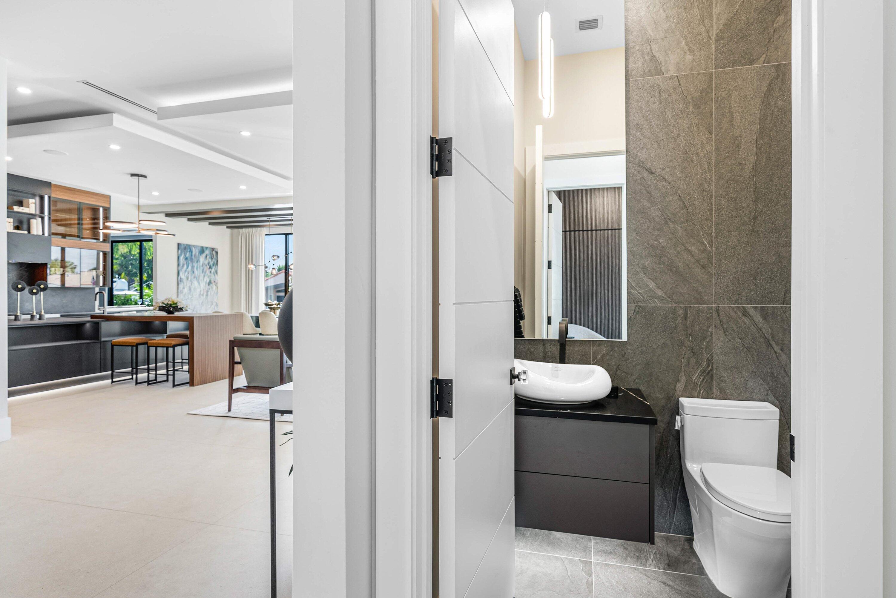 728 Enfield Street Boca Raton, FL 33487 - Photo 38 of 50 a bathroom with a toilet a sink and a mirror