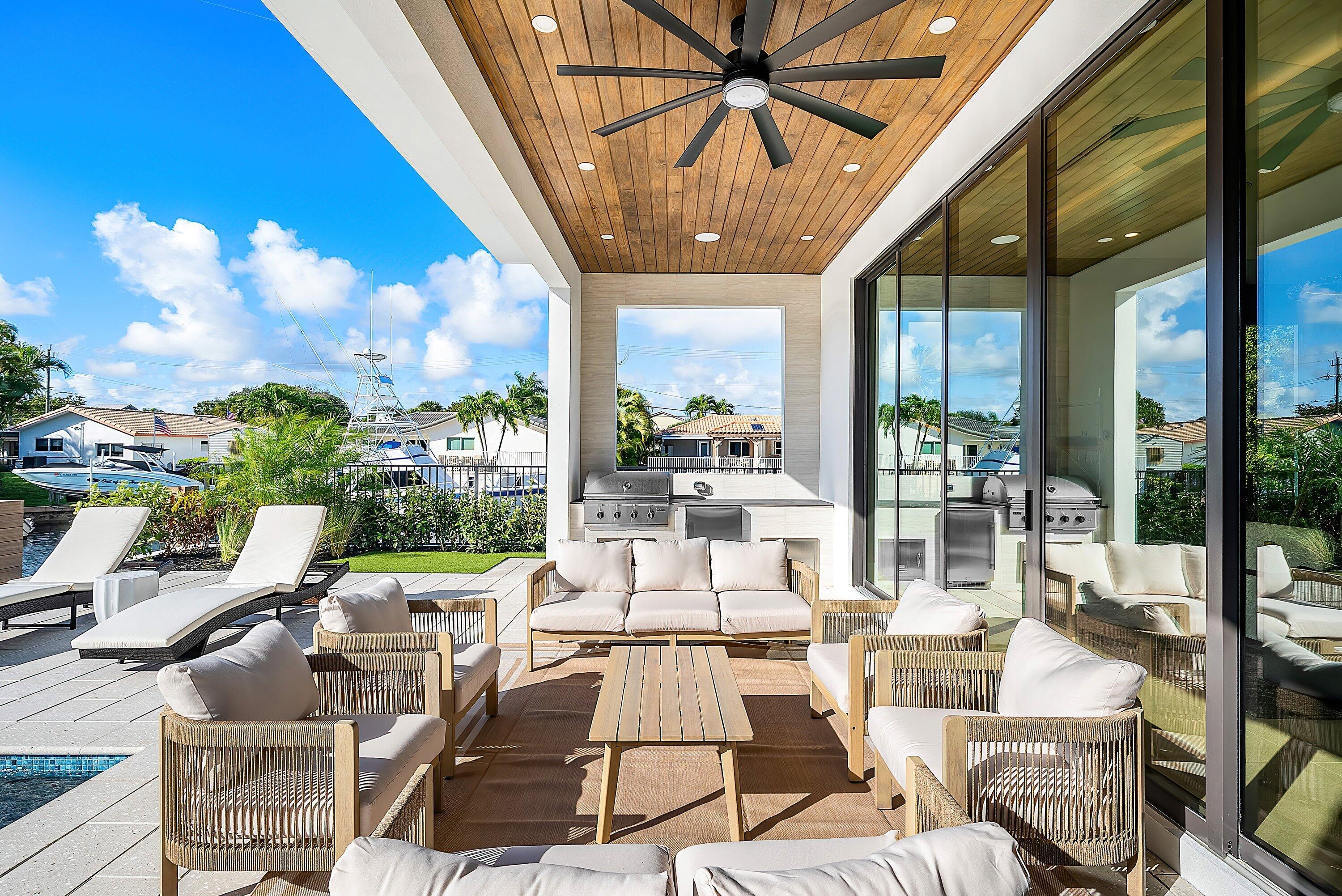 728 Enfield Street Boca Raton, FL 33487 - Photo 42 of 50 a view of a patio with couches chairs dining table and chairs with wooden floor