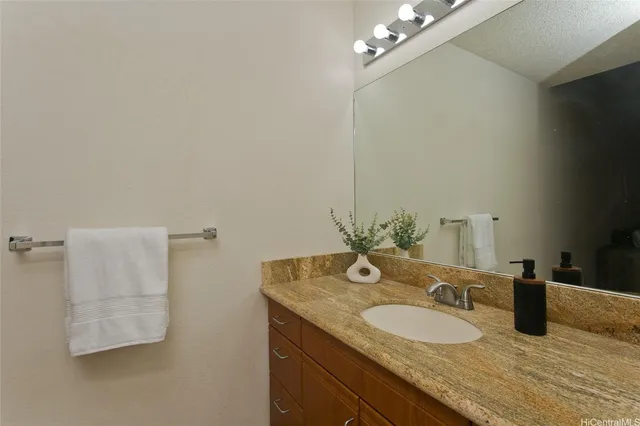 a bathroom with a granite countertop sink and a mirror