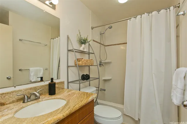 a bathroom with a granite countertop sink toilet and shower