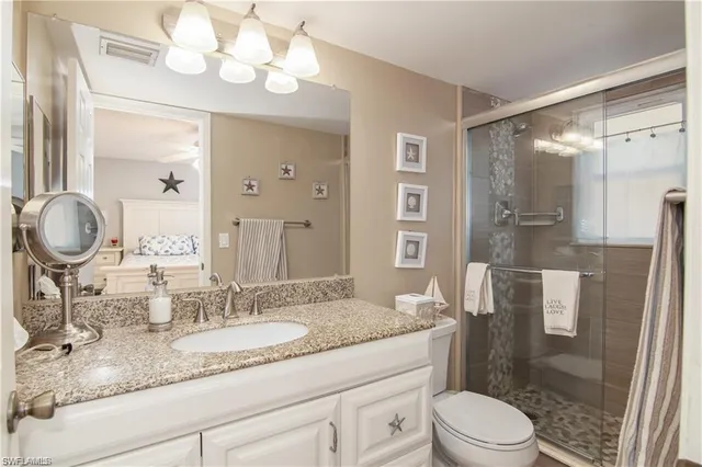 a bathroom with a granite countertop sink a toilet and a mirror