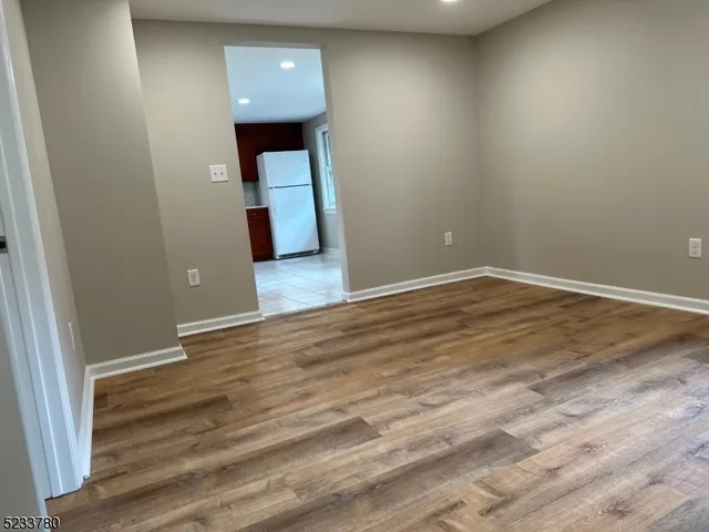 a view of a hallway with wooden floor and a sink