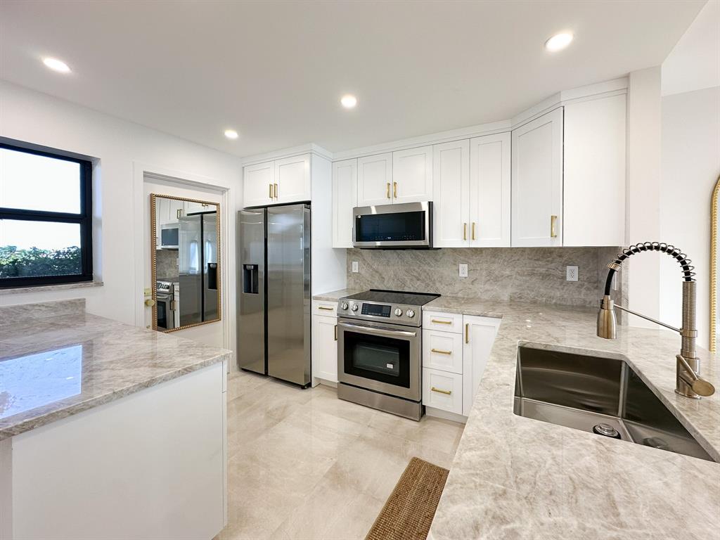 4800 Bayview Drive, Unit 503 Fort Lauderdale, FL 33308 - Photo 2 of 30 a kitchen with stainless steel appliances granite countertop a stove a sink and a refrigerator