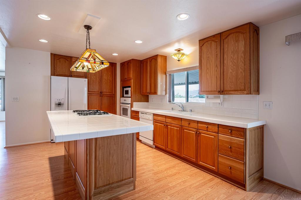 4650 Dulin Road, Unit 119 Fallbrook, CA 92003 - Photo 16 of 49 a kitchen with stainless steel appliances granite countertop wooden cabinets sink and stove