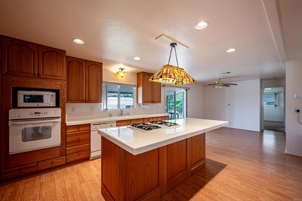 4650 Dulin Road, Unit 119 Fallbrook, CA 92003 - Photo 24 of 49 a kitchen with stainless steel appliances granite countertop wooden cabinets a stove a sink and a refrigerator