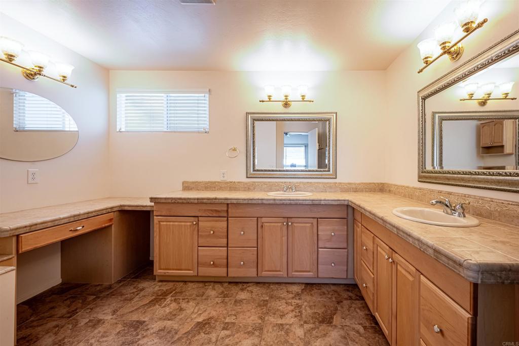 4650 Dulin Road, Unit 119 Fallbrook, CA 92003 - Photo 31 of 49 a spacious bathroom with a granite countertop sink and a mirror